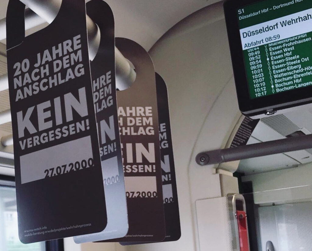 2020: Zum 20 Jahrestag des Anschlags werden hunderte Info-Hänger für die Fahrgäste der Bahnen und Busse verteilt, die an der Station Wehrhahn halt machen. (Foto: Erinnerungsort Alter Schlachthof)